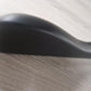 Close-up of a Rustic Motifs Wooden Black Jacket 39cm with a curving shape, resting on a light wood surface. A chunky hanger subtly sits beneath it, blending into the scene. The background is slightly blurred, making it difficult to identify the specific object.