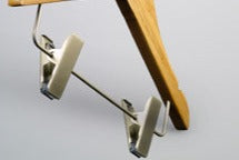 A Bamboo Wood Sustainable Children's Top Clip Hanger 26cm by Rustic Motifs is shown against a plain, light background. The eco-friendly hanger is angled slightly and designed to hold clothing items such as skirts or pants.