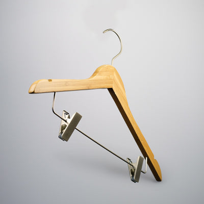 A Bamboo Wood Sustainable Top Clip Hanger 42cm from Rustic Motifs, with a metal hook and integrated clips for hanging pants or skirts, set against a light gray background. The design is simple and functional, making it a perfect eco-friendly clothing organizer for various garments.