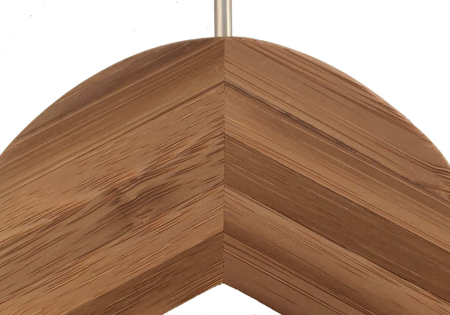 Close-up of the corner of a wooden picture frame with a chevron design. The frame features a smooth, polished finish, highlighting the grain patterns and knots in the wood. With its rustic look and natural texture, it harmonizes beautifully with an eco-friendly clothing organizer or Rustic Motifs's Bamboo Wood Sustainable Top Clip Hanger 42cm.
