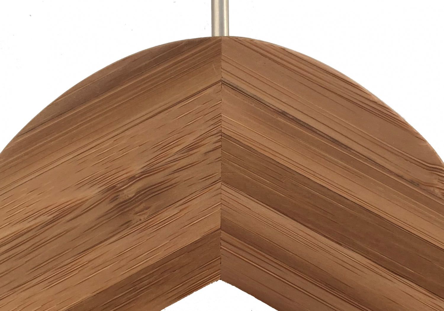 Close-up of the corner of a wooden picture frame with a chevron design. The frame features a smooth, polished finish, highlighting the grain patterns and knots in the wood. With its rustic look and natural texture, it harmonizes beautifully with an eco-friendly clothing organizer or Rustic Motifs's Bamboo Wood Sustainable Top Clip Hanger 42cm.