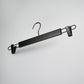 A Rustic Motifs Black Wooden Clip Bottom Hanger 37cm with two sturdy, adjustable clips, designed for hanging pants or skirts. The Rustic Motifs hanger features a hook at the top that offers 360-degree rotation for easy positioning on any rod or bar. It rests against a plain, light grey background.