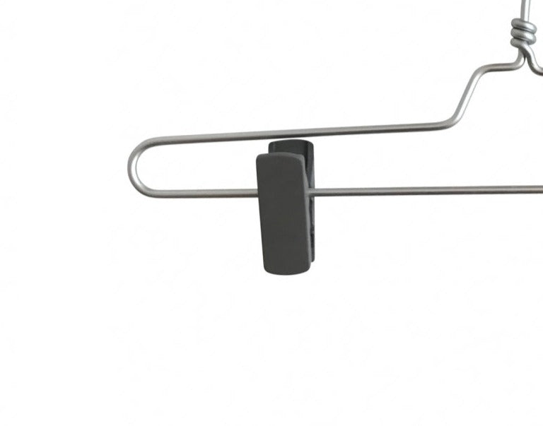 A close-up of a Rustic Motifs Natural Aluminium Clip Bottom Hanger 35cm with a black plastic clip attached to it. The hanger boasts a simple and minimalist design, featuring a hook on top for hanging. The background is plain white.