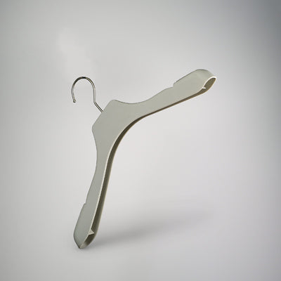 A single beige Rustic Motifs Premium Soft Touch Plastic Coat Hanger 39cm with a metal hook is suspended in front of a neutral gray background. The elegant hanger features a curved design to accommodate the shape of garments, perfect for enhancing closet organization.