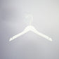 A White Wood Sustainable Thick Top Jacket Bridal Hanger with Hooks 39cm from Rustic Motifs is hanging against a light gray background. This sustainable hanger features a standard hook at the top and notches on each side for securing garments with straps.
