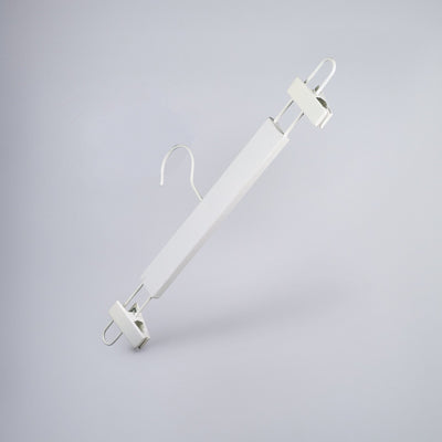 Introducing the Rustic Motifs White Wooden Clip Bottom Hanger 37cm, a minimalistic clothes hanger designed for crease-free garment organization. It features a broad central bar and metal hooks at both ends for gripping the waistband, with a rotating hook at the top. The premium wood hanger is set against a plain light grey background.